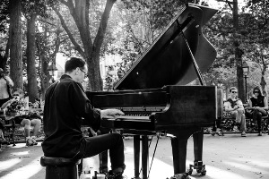 adult man learning piano in park